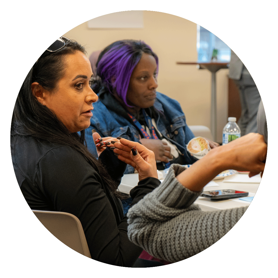Diverse group of people talking around a table.