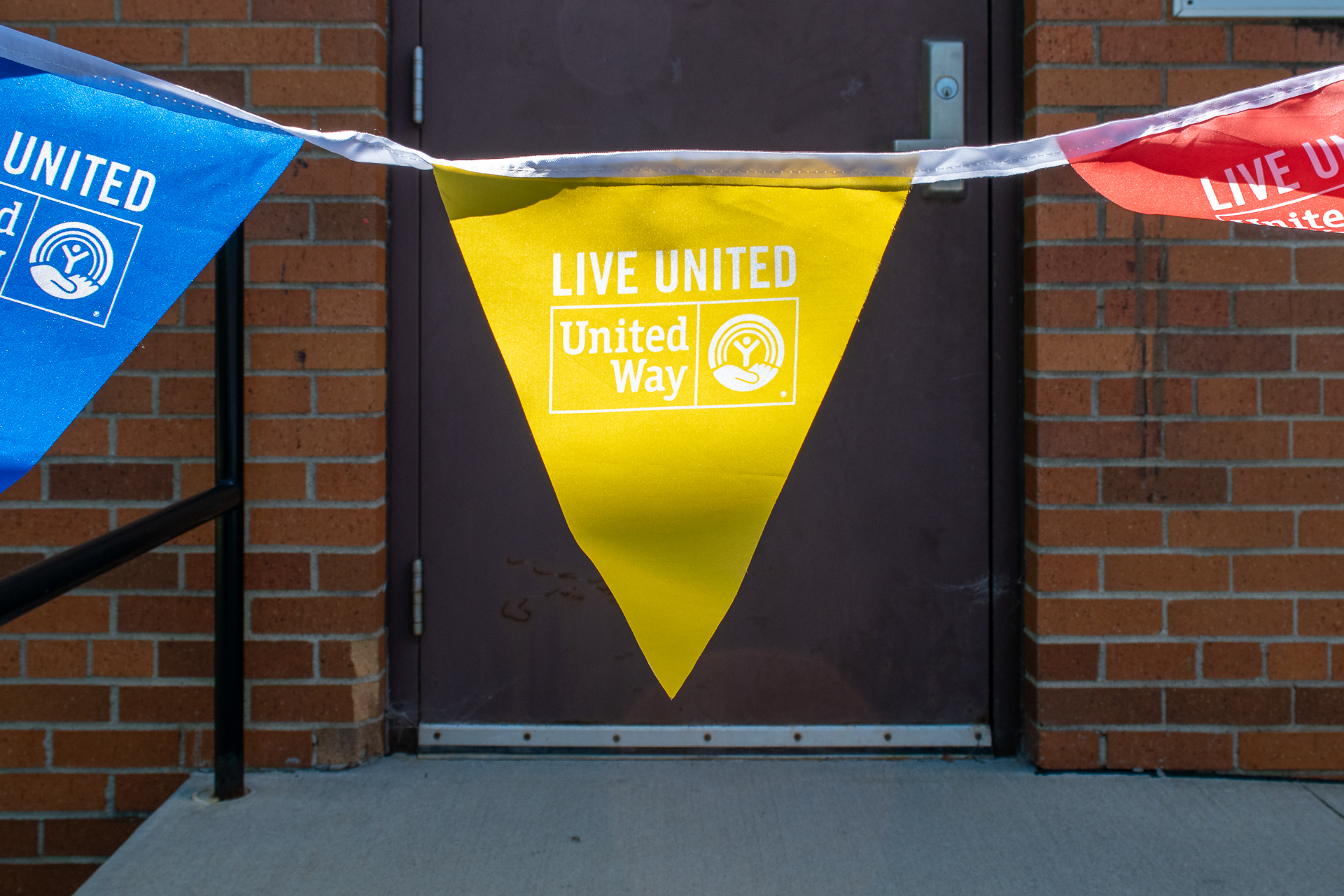 Photo of blue, yellow, and red Live United - United Way pennant flags