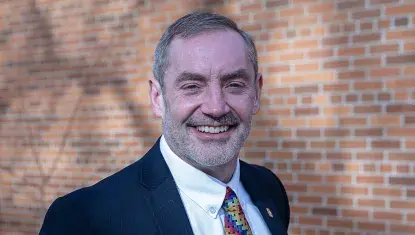 White man in suit smiling.